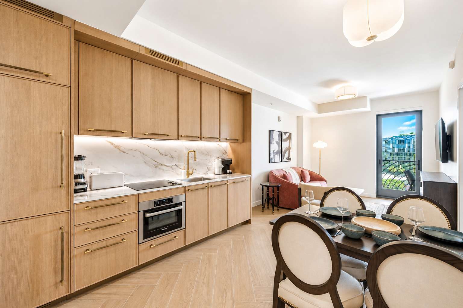 Kitchen and dining area with light wood cabinetry.