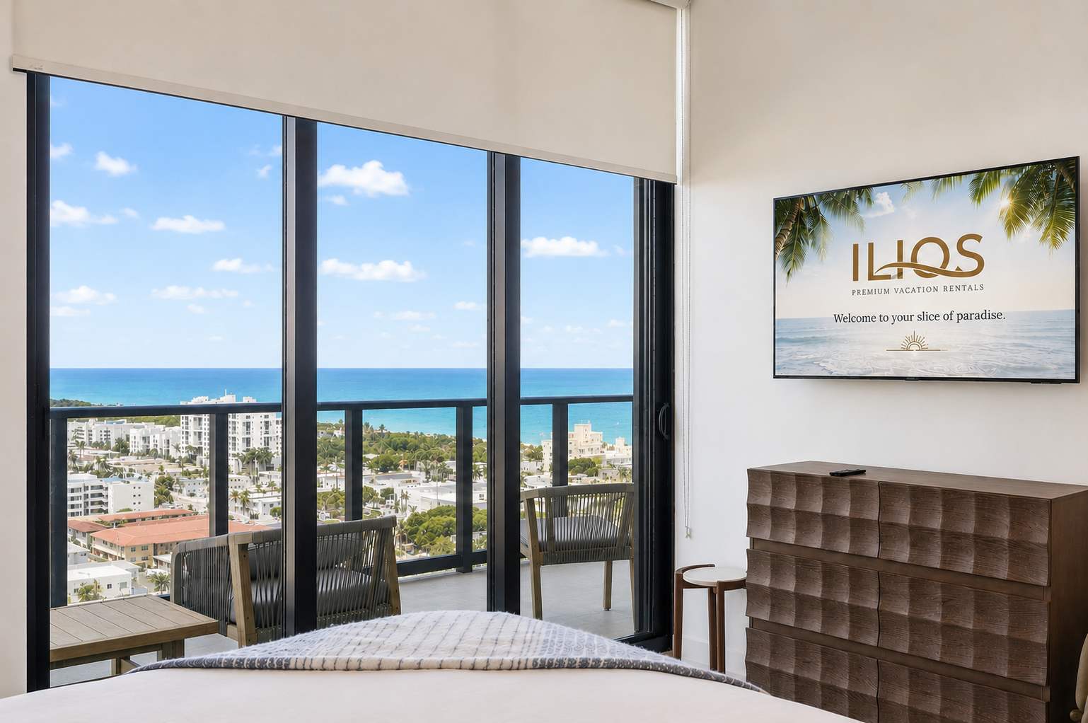 Bedroom television beside ocean-view balcony doors.