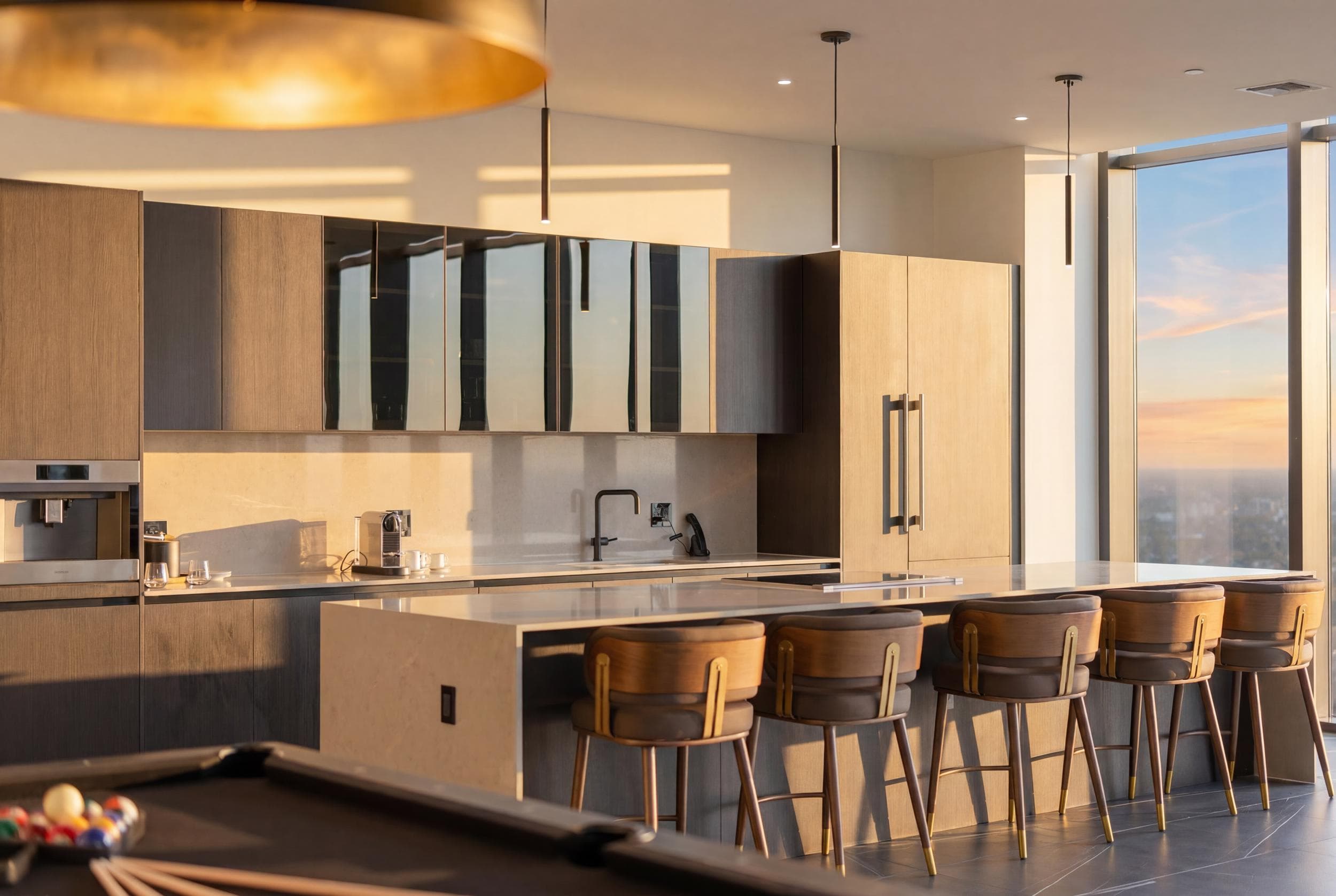 Kitchen island beneath slim pendant lights.