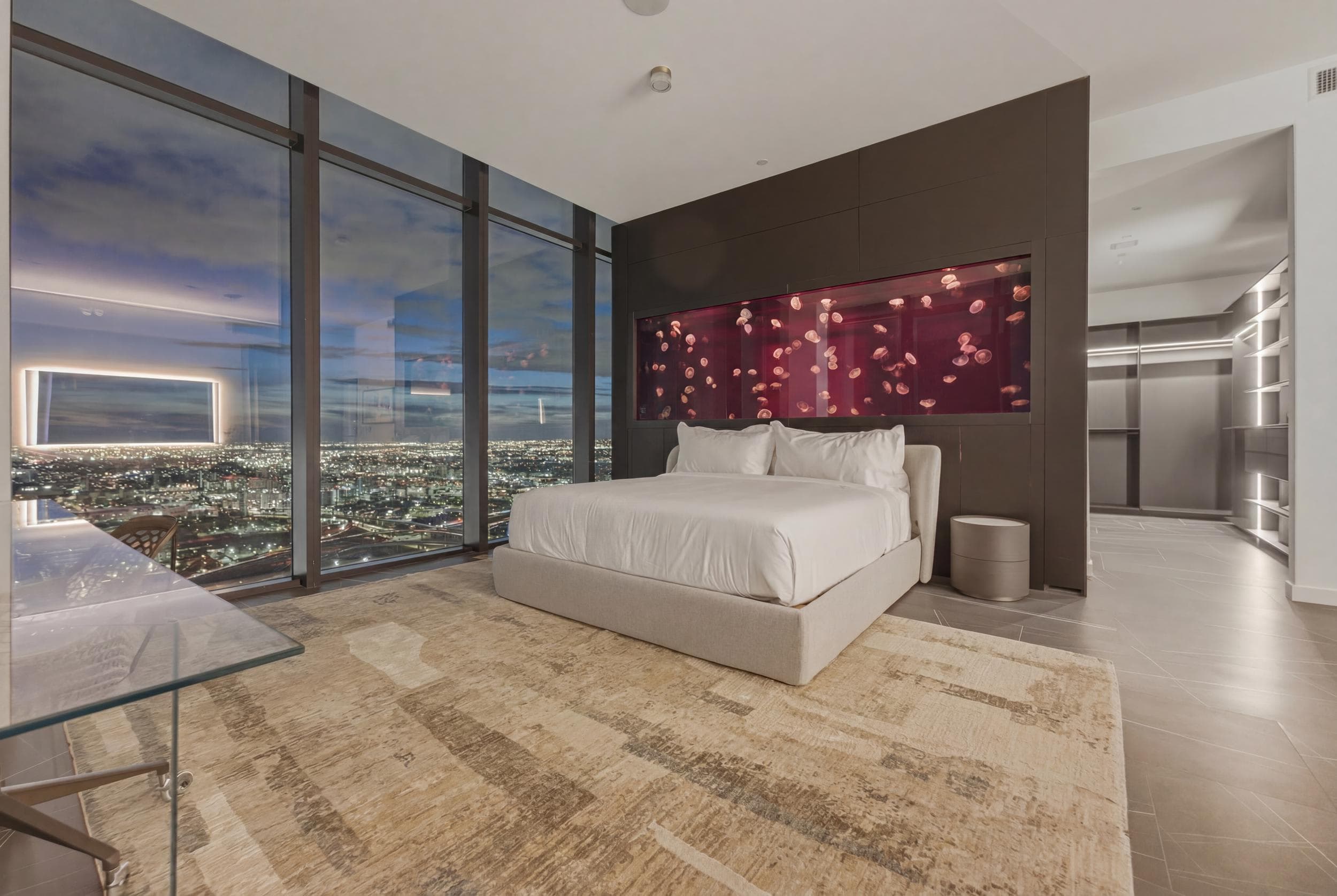 Bedroom with illuminated pink wall artwork.