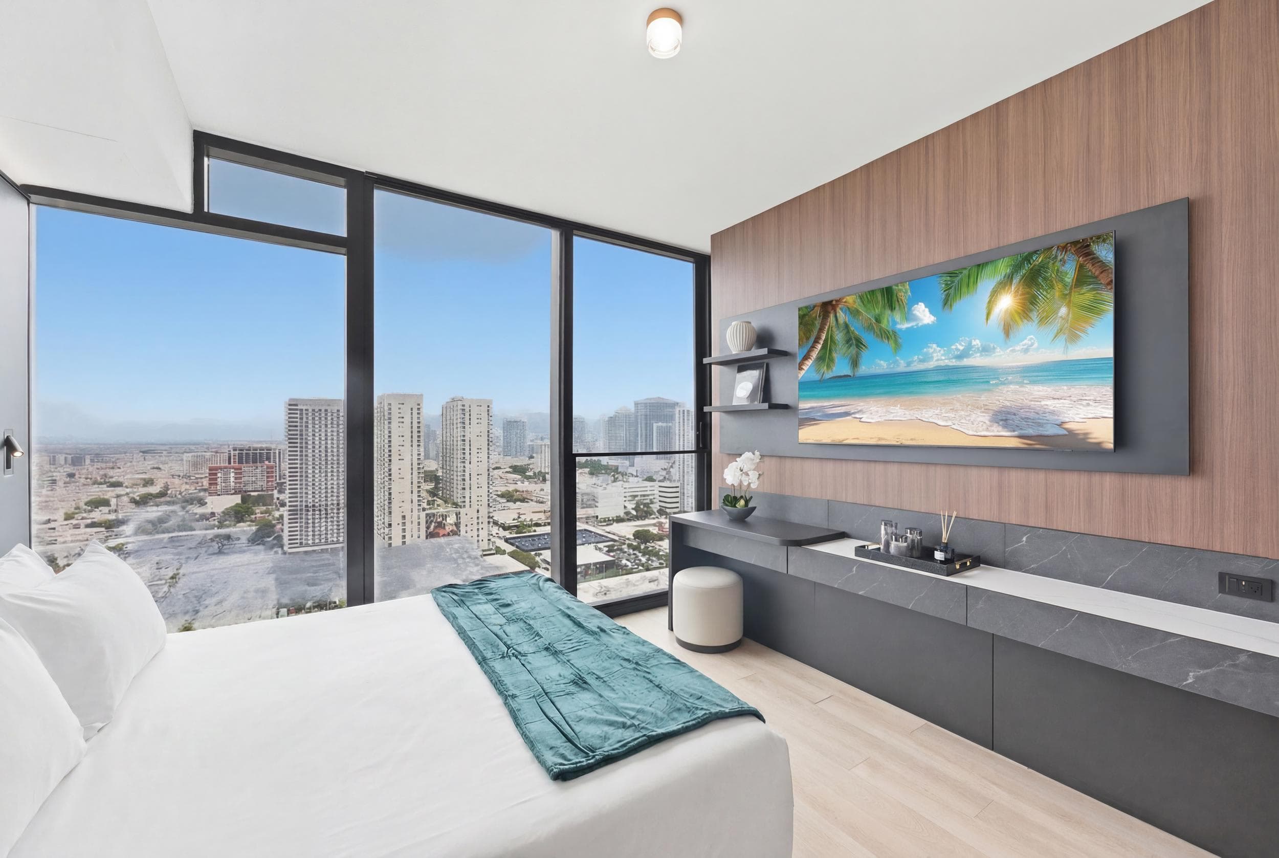 Bed facing a wall-mounted TV and long console.