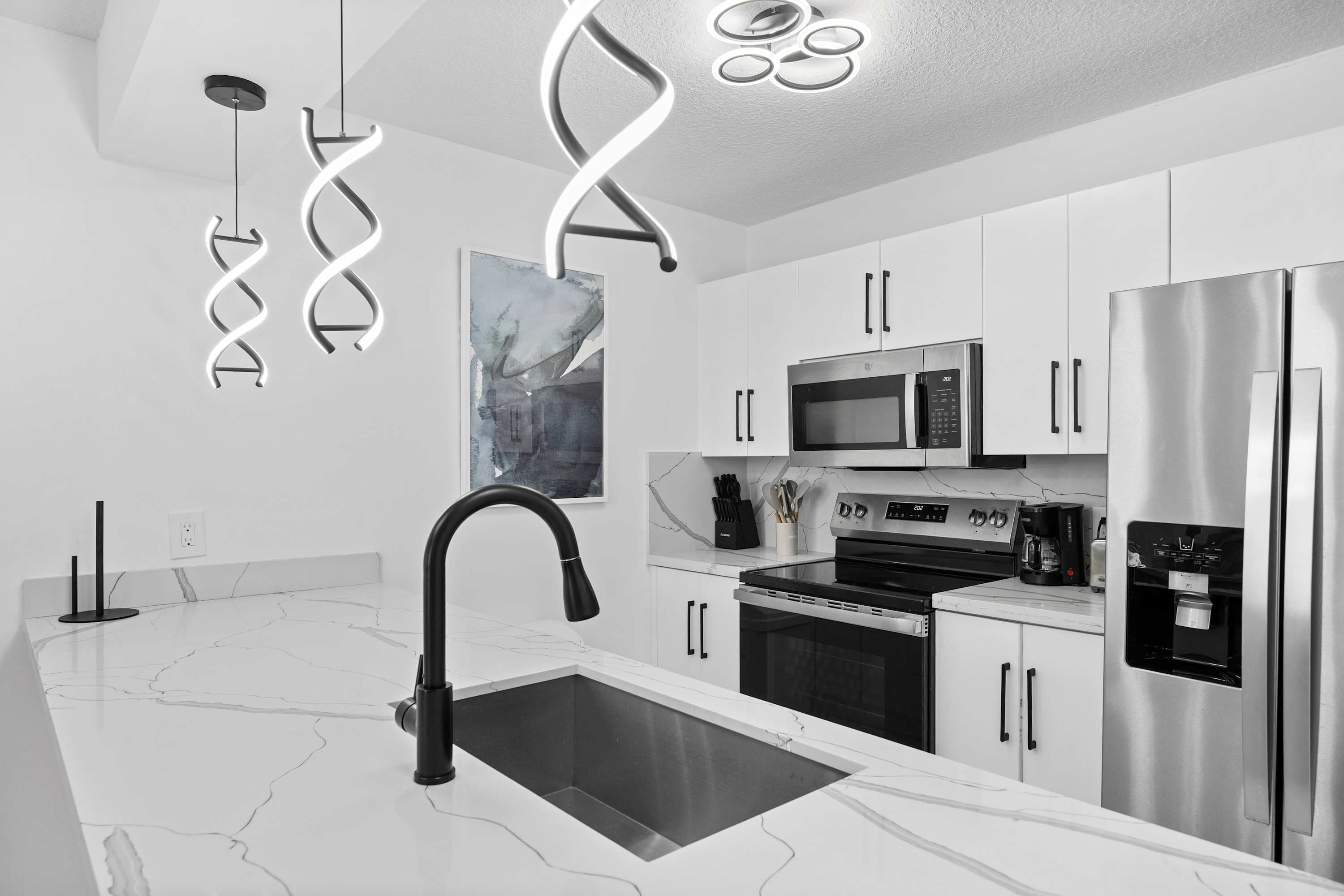 White kitchen with stainless steel appliances.