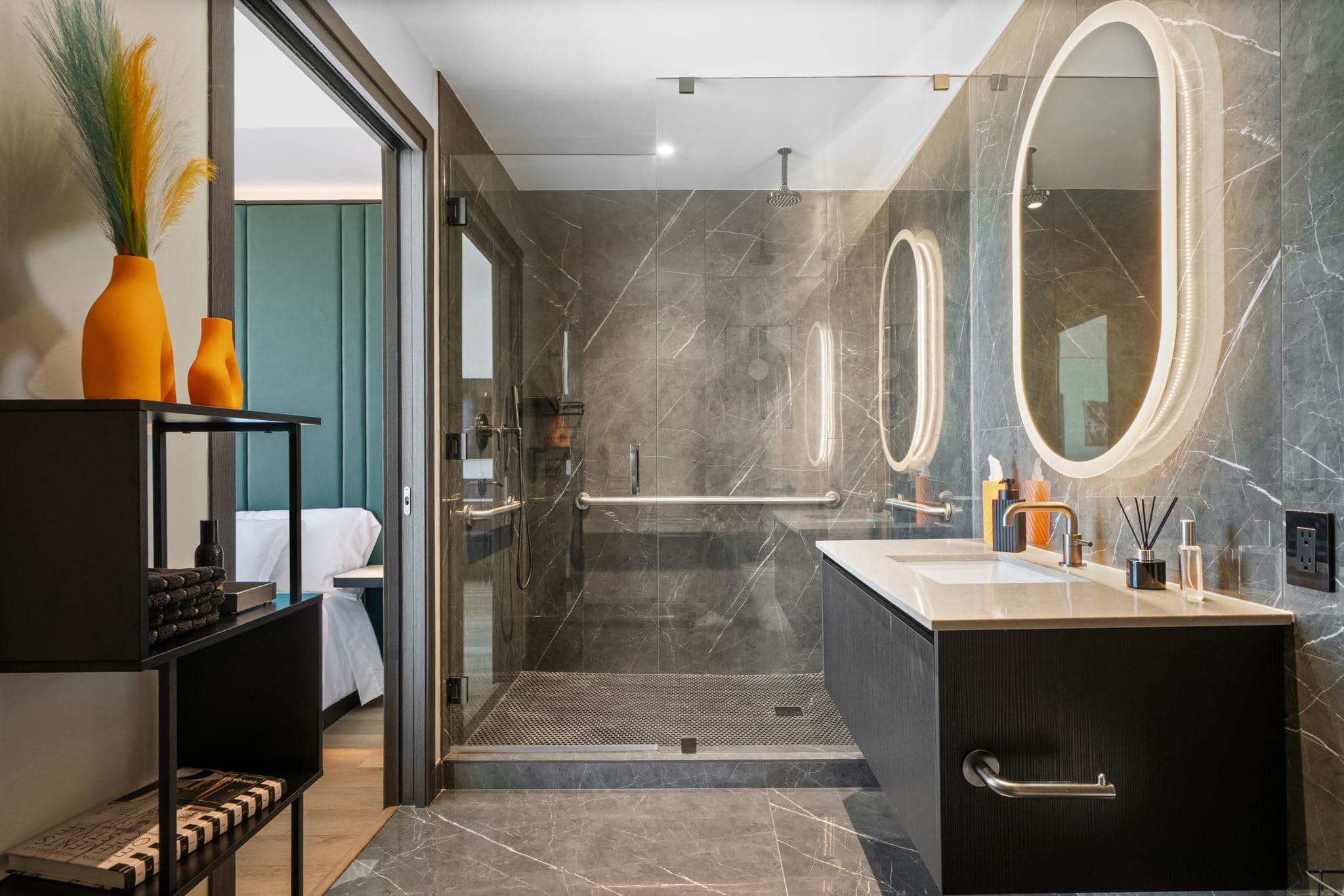Marble bathroom with an oval mirror and shower.
