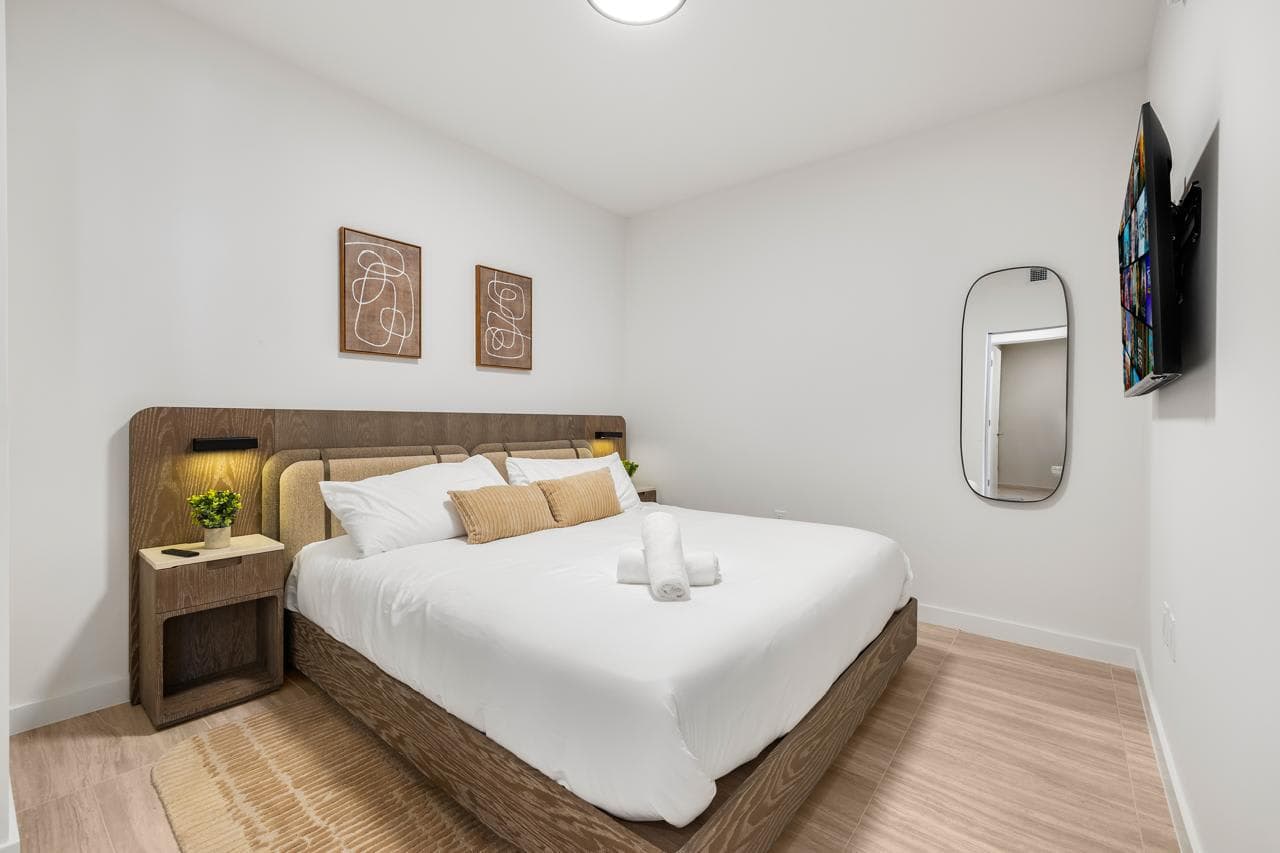 Bedroom with white bedding and framed artwork.