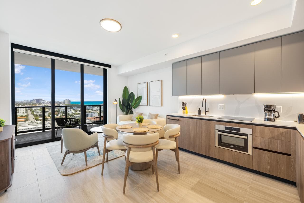 Open kitchen and dining area beside balcony doors.