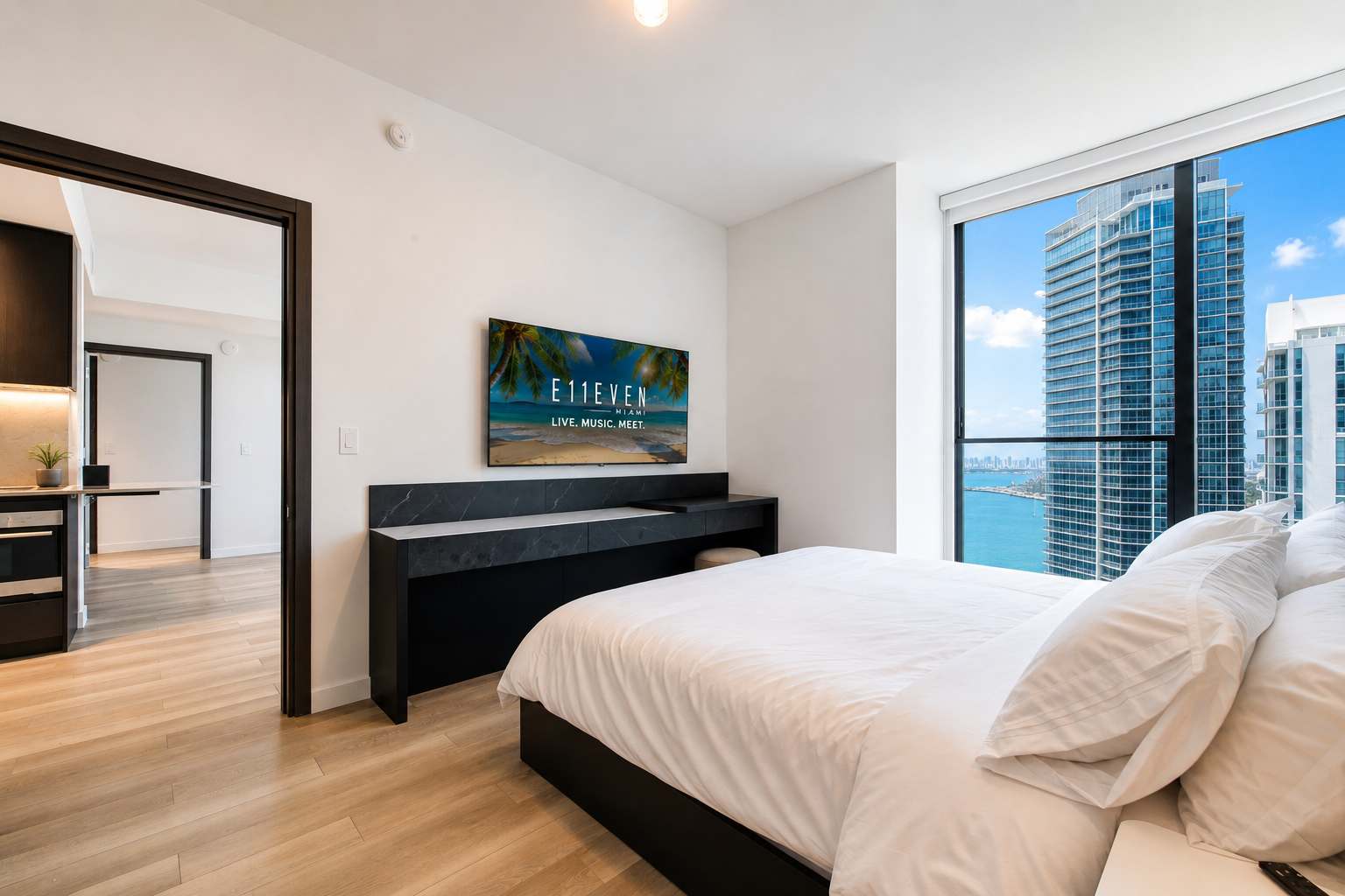 Bed facing a wall-mounted television.