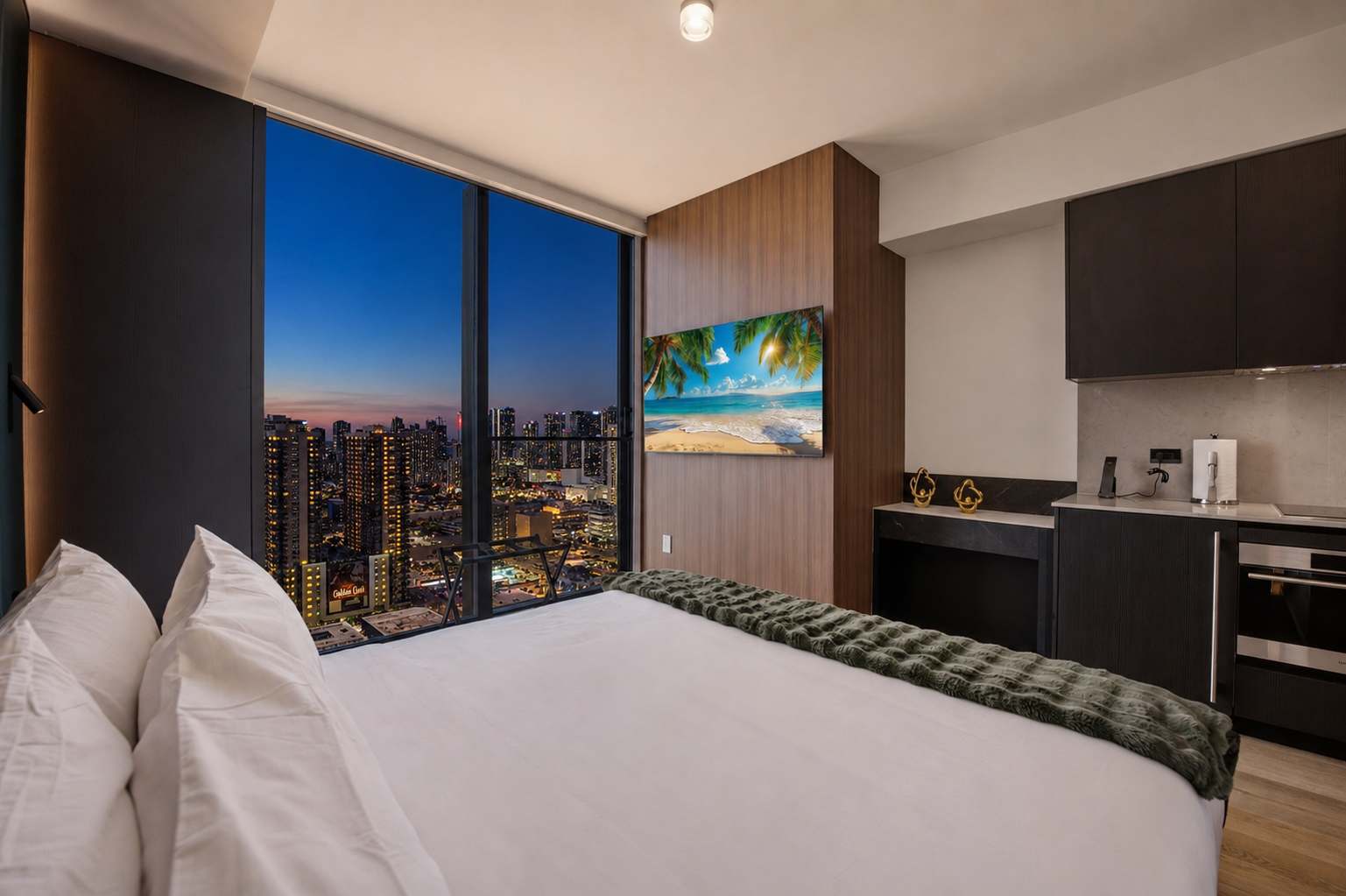 Bed beside the kitchen and city lights.