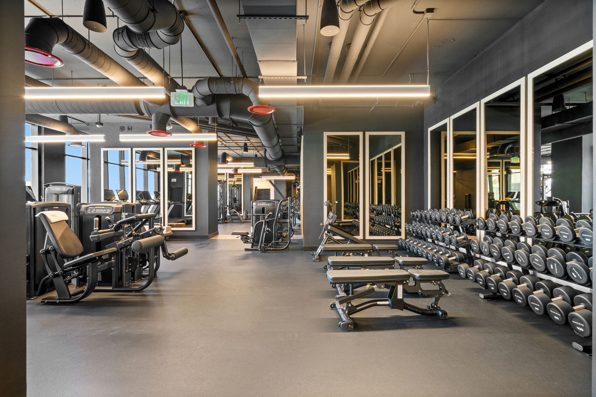 Gym with dumbbell racks and strength equipment.