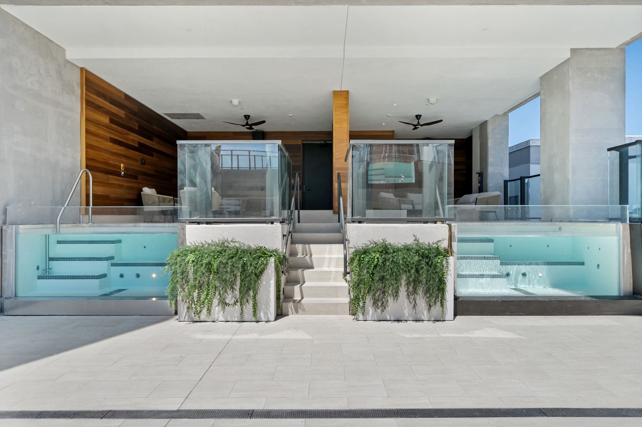 Outdoor terrace with pale seating and planters.