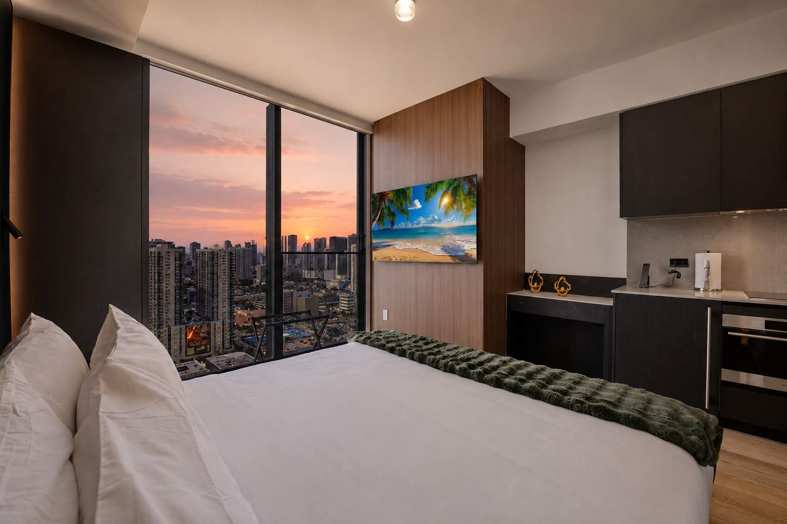 Bed beside a compact kitchen at sunset.