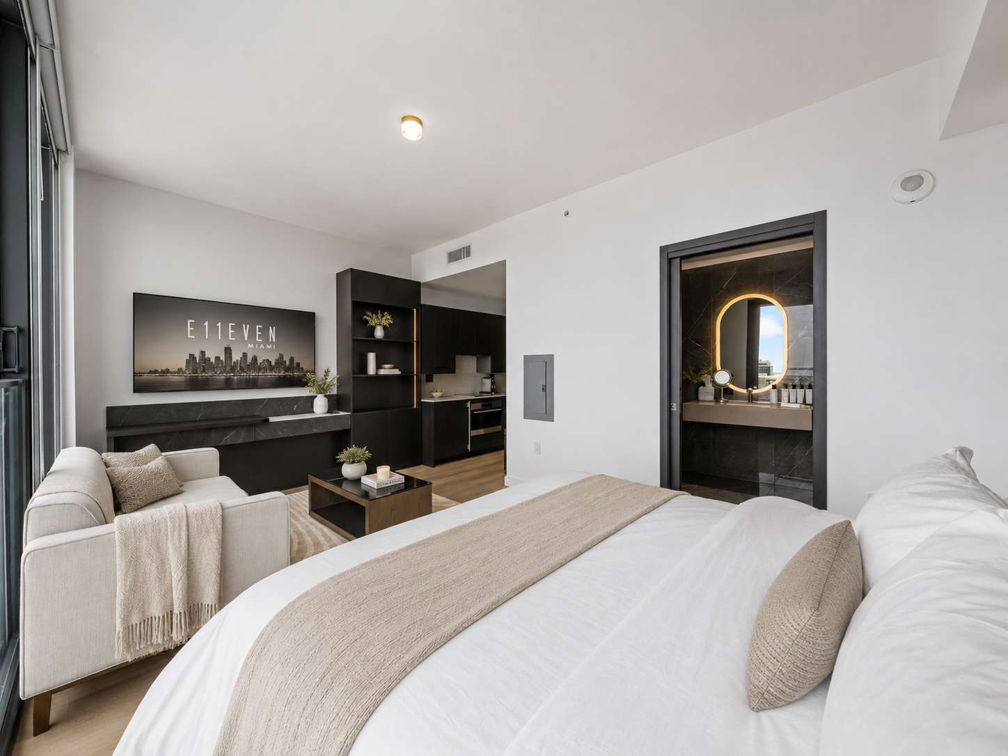 Bed beside a sofa and television console.