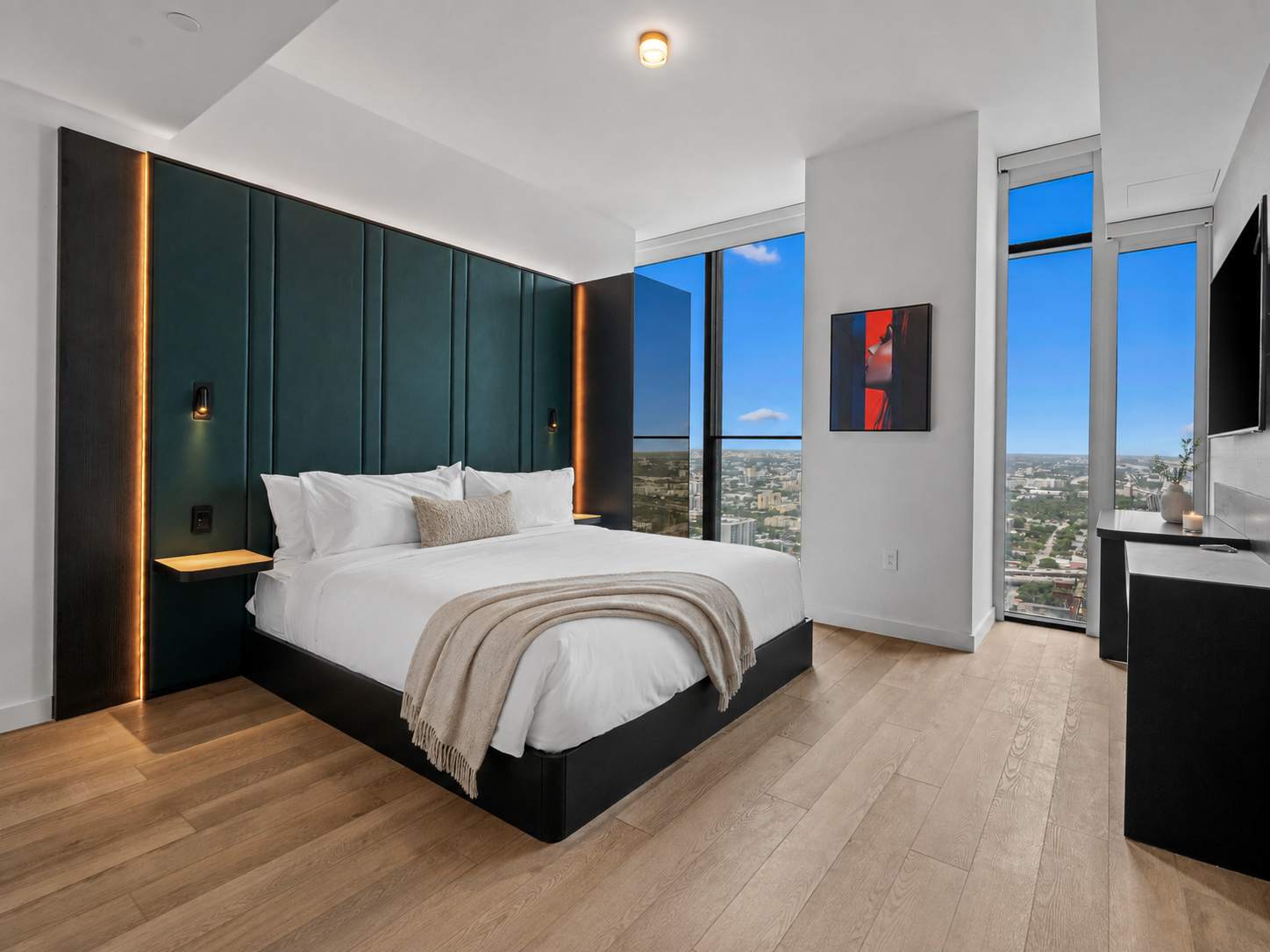 Bed with a striped throw beside tall windows.