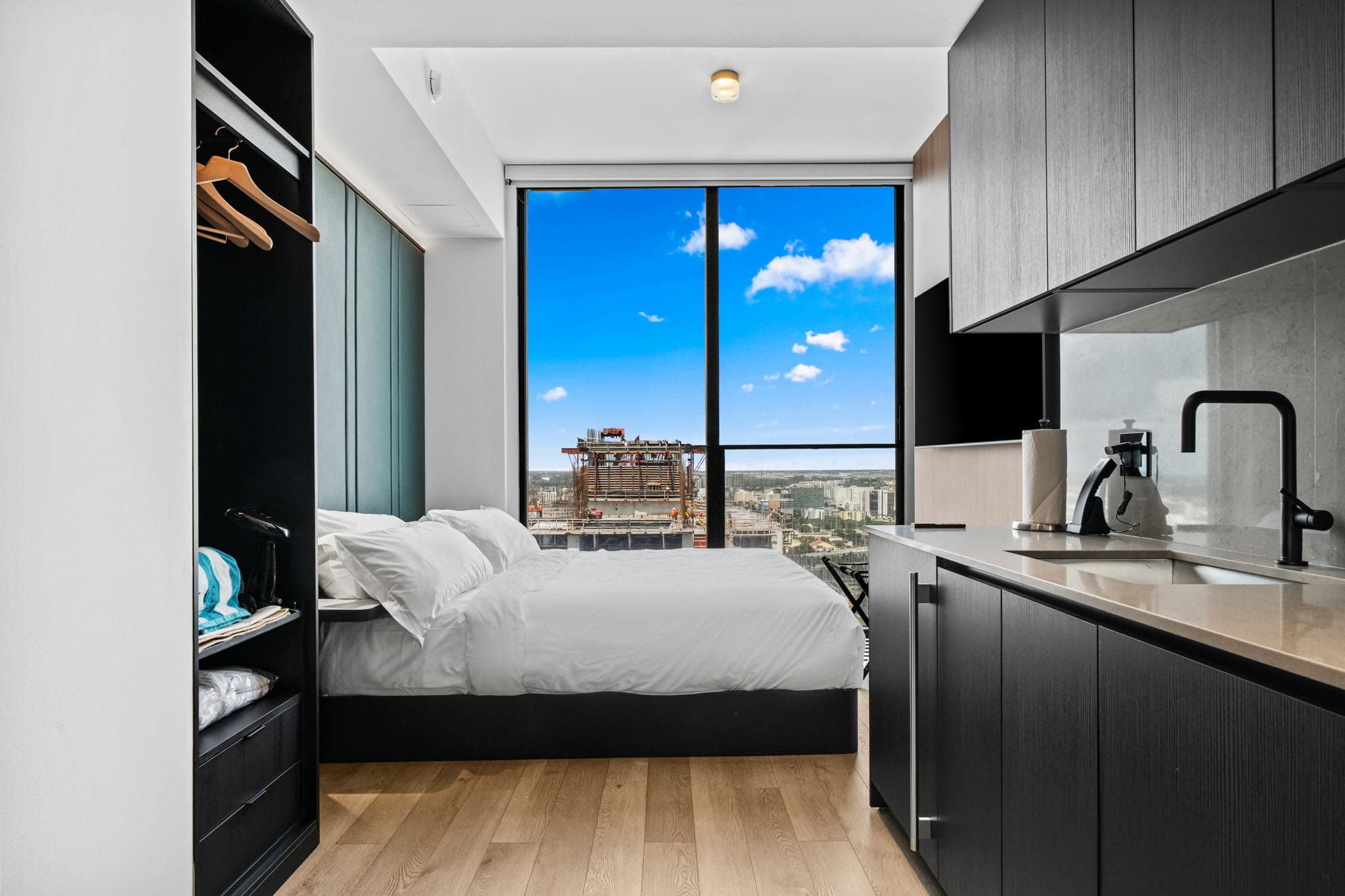 Compact studio with a kitchen beside the bed.