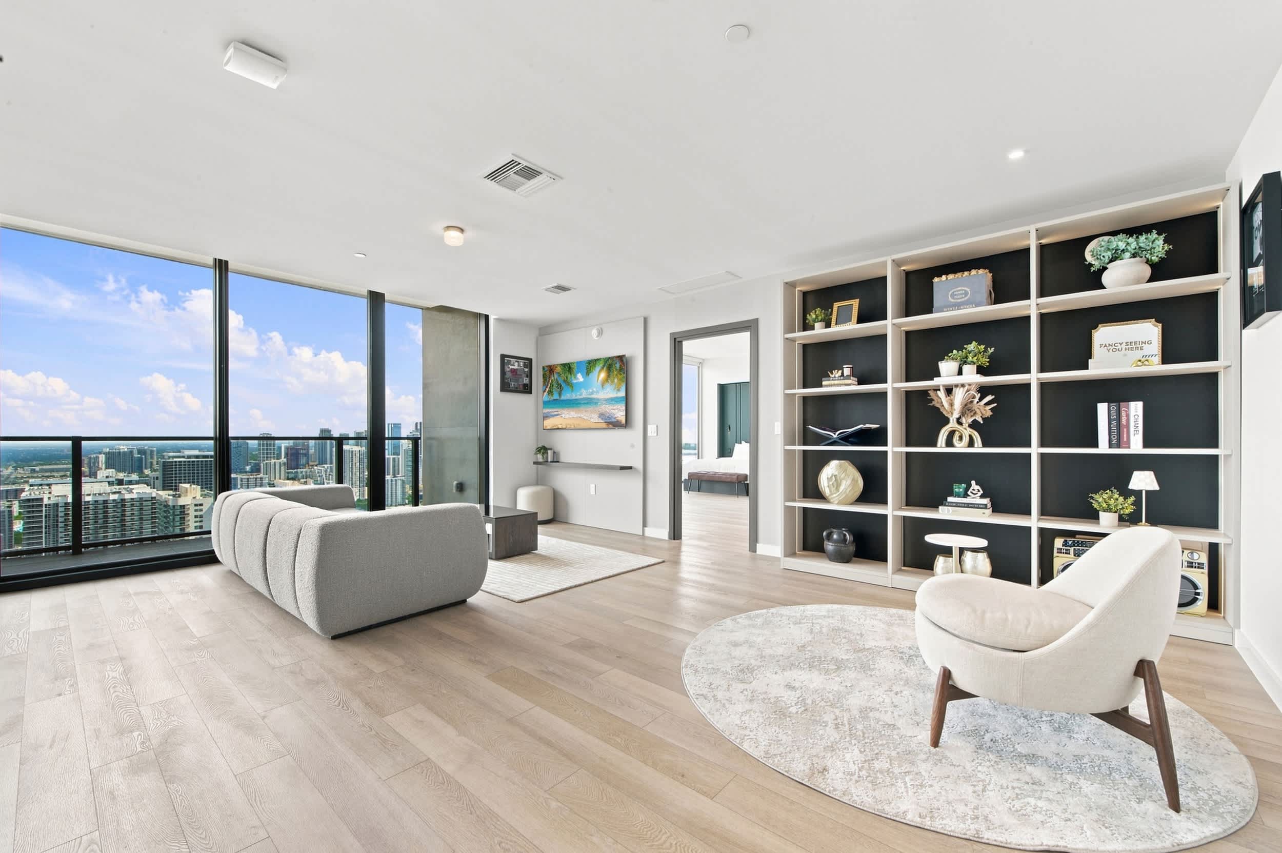 Living room with display shelves and city views.