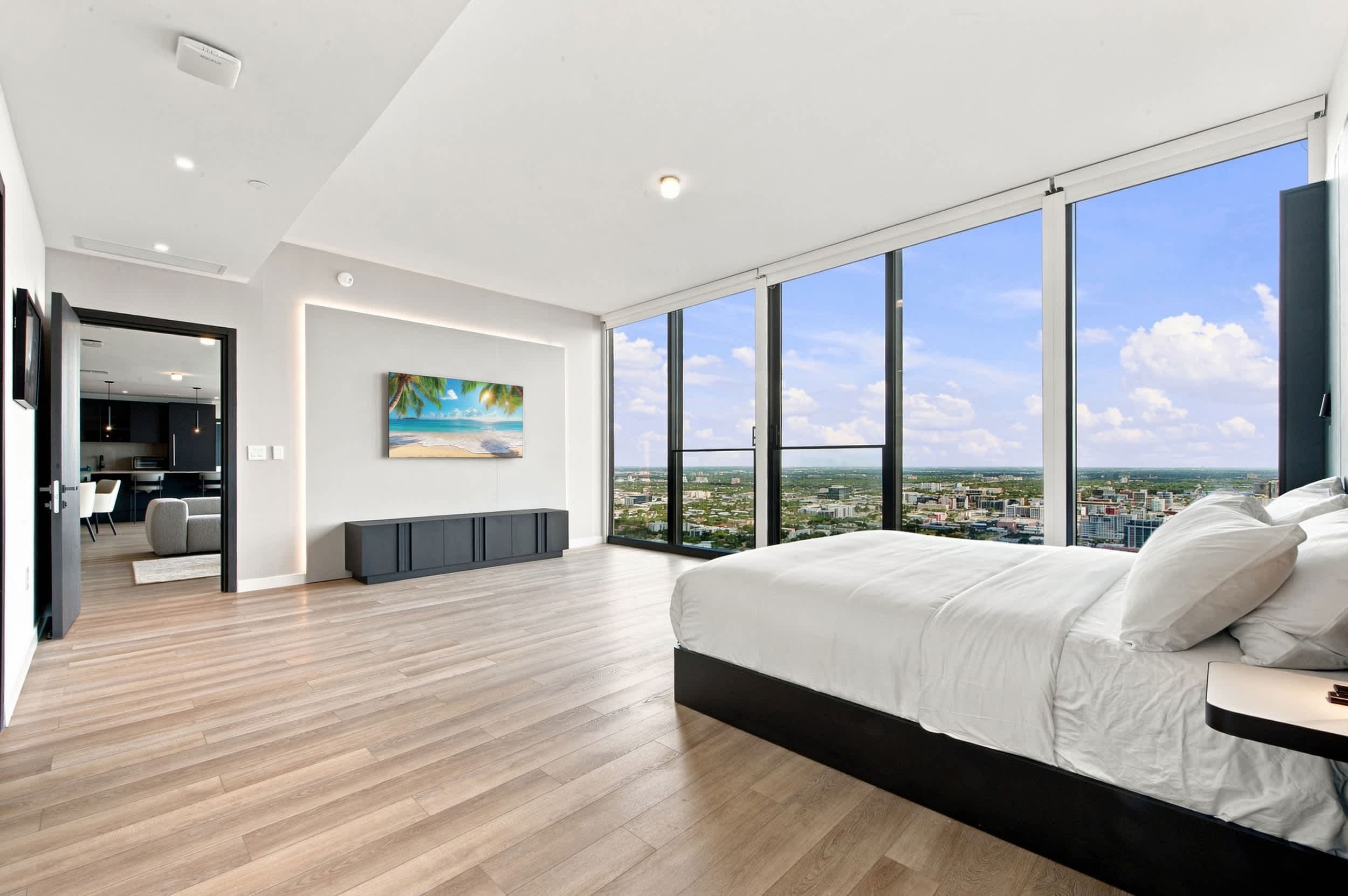 Spacious bedroom with floor-to-ceiling city views.