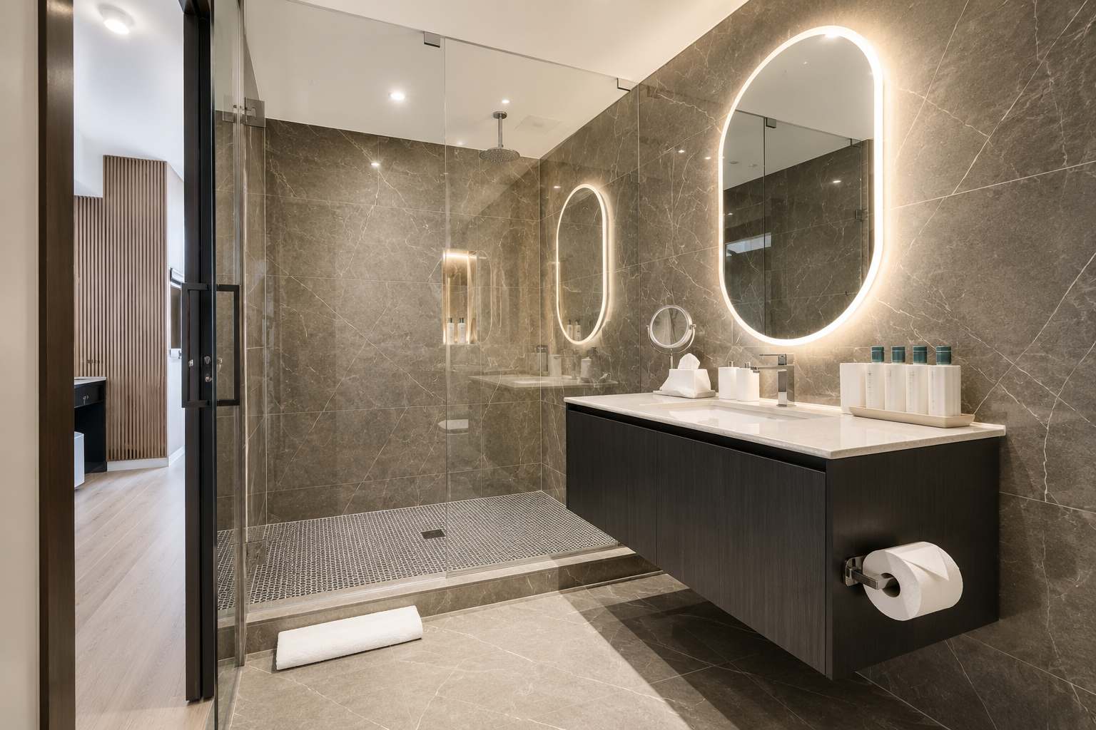 Marble bathroom with an oval mirror and shower.