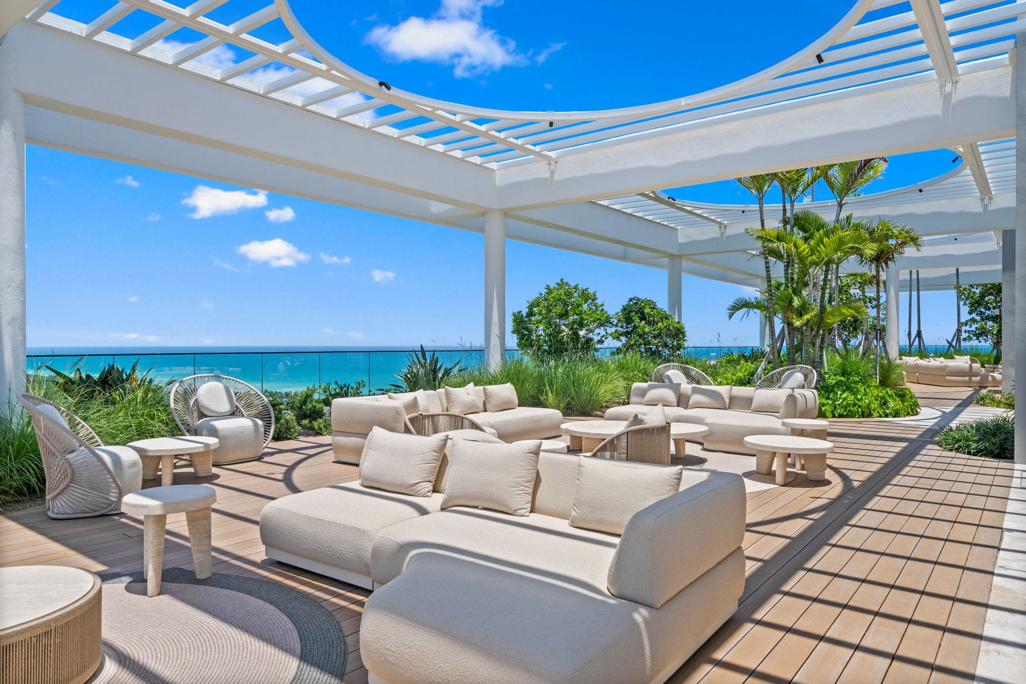 Outdoor lounge beneath a white pergola.