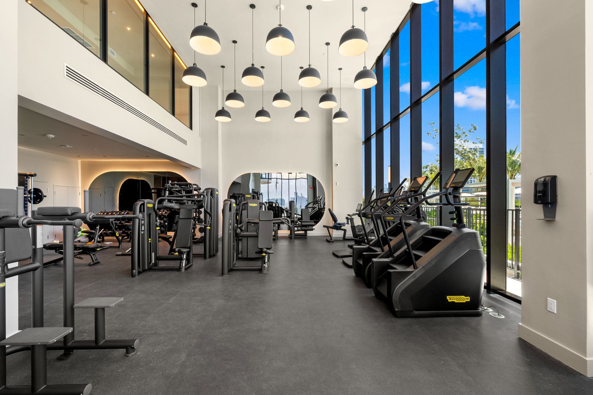 Gym with tall windows and strength equipment.