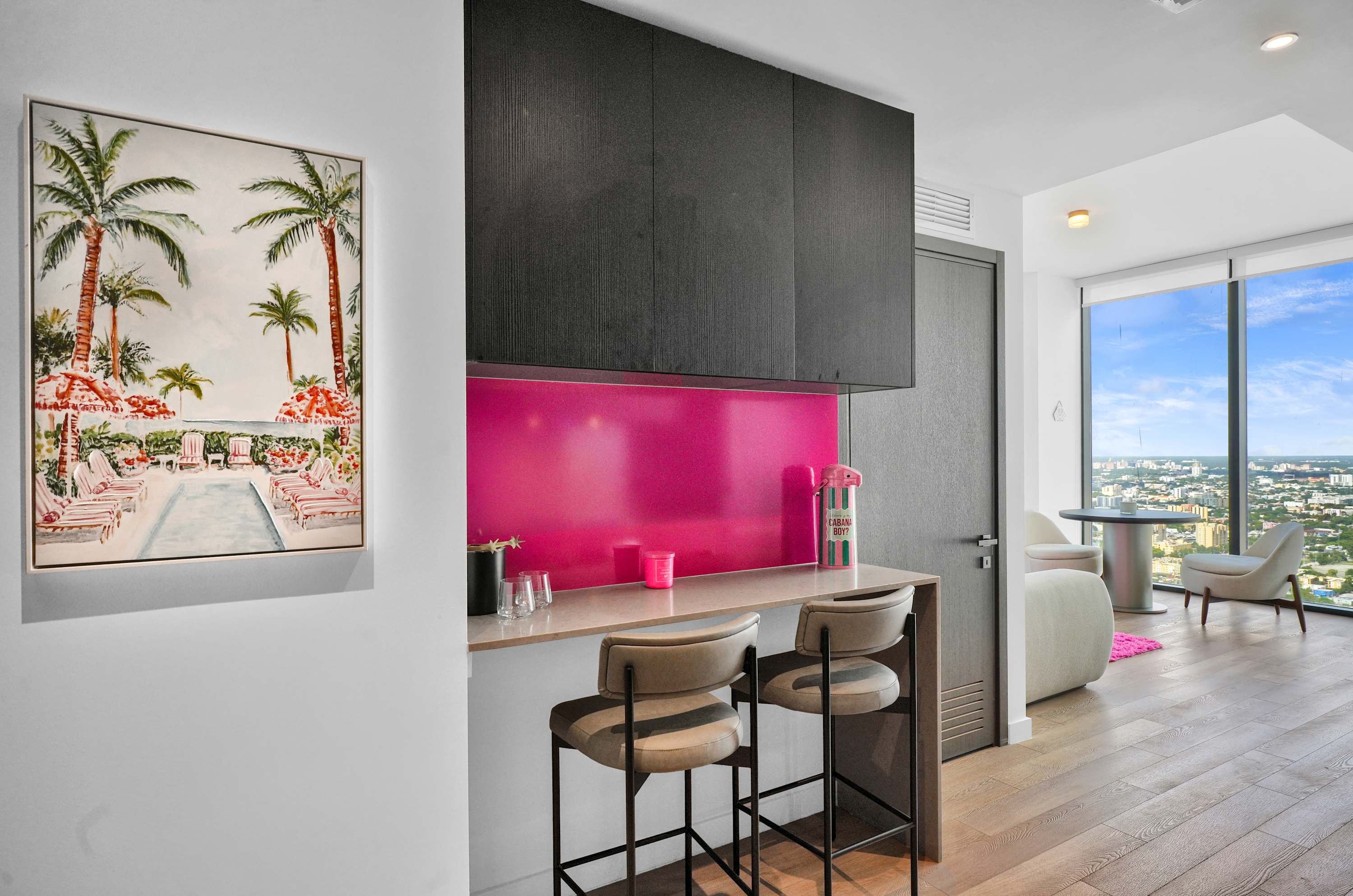 Breakfast bar with stools and a bright pink backsplash.