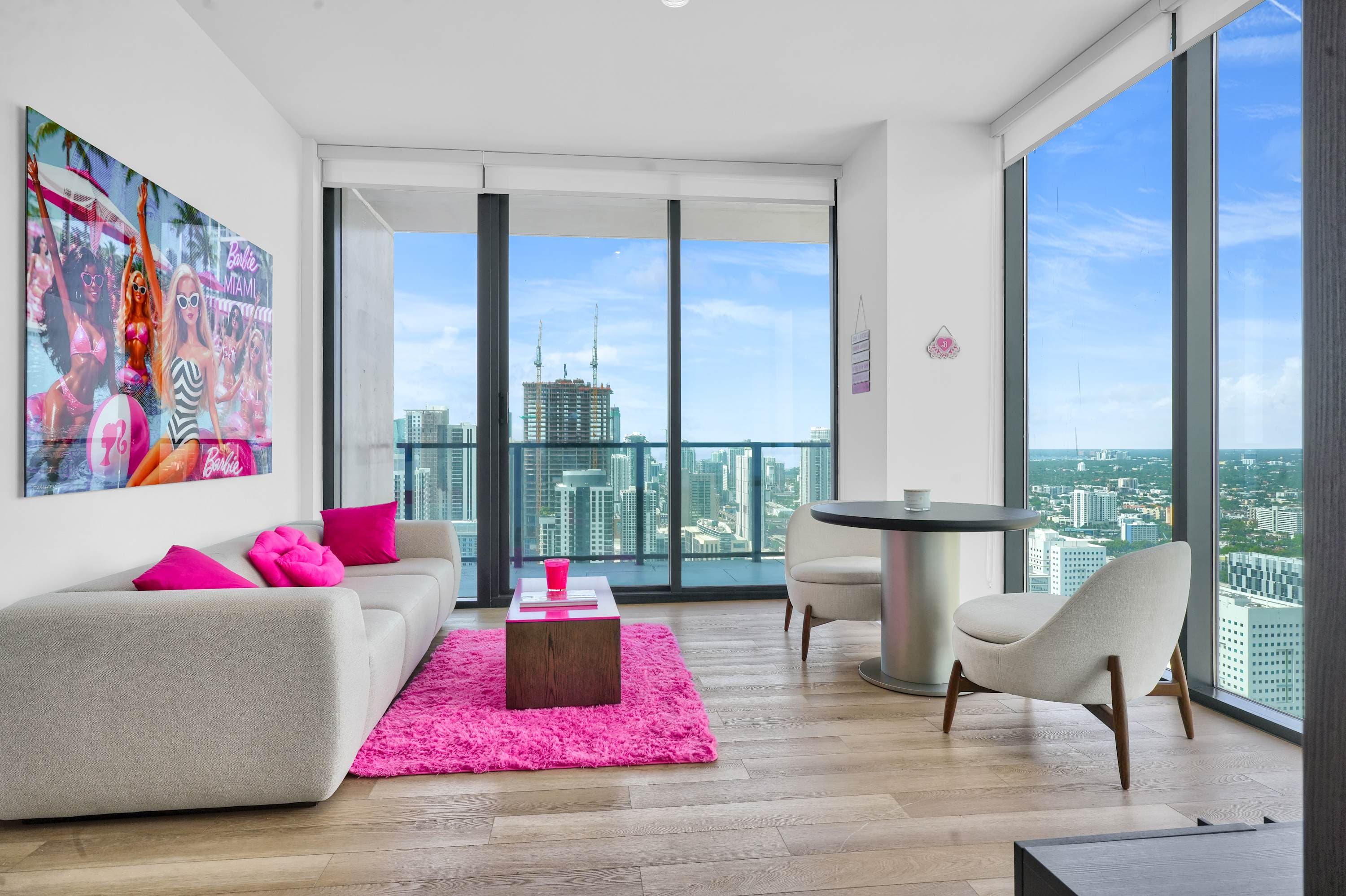 Living room with pink cushions and a bright pink rug.